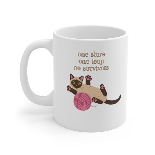 White coffee mug with Siamese cat graphic and one stare one leap no survivors slogan shown from left side