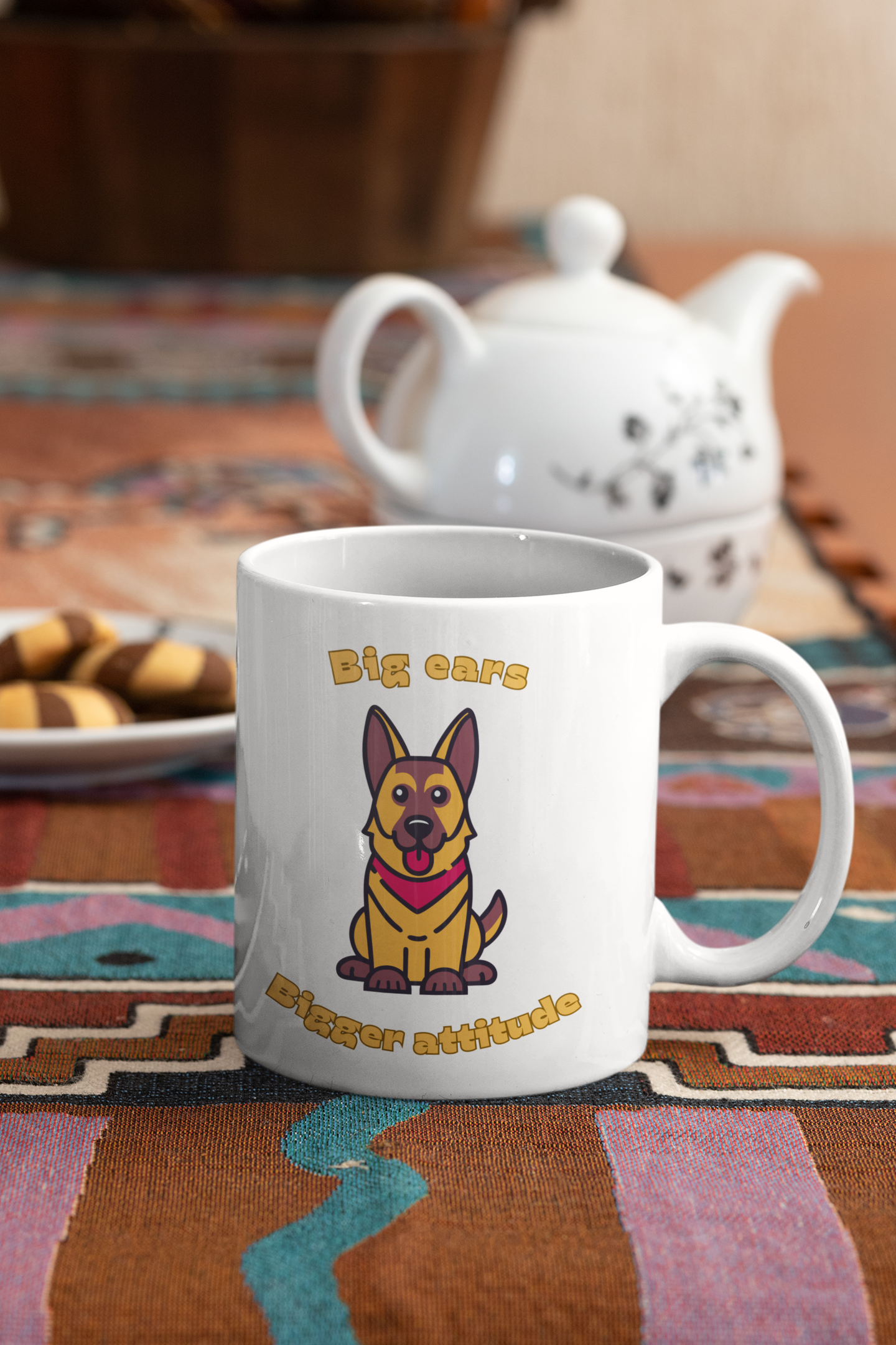 11 oz white coffee mug with German Shepherd graphic and big ears bigger attitude slogan placed near biscuits and a teapot