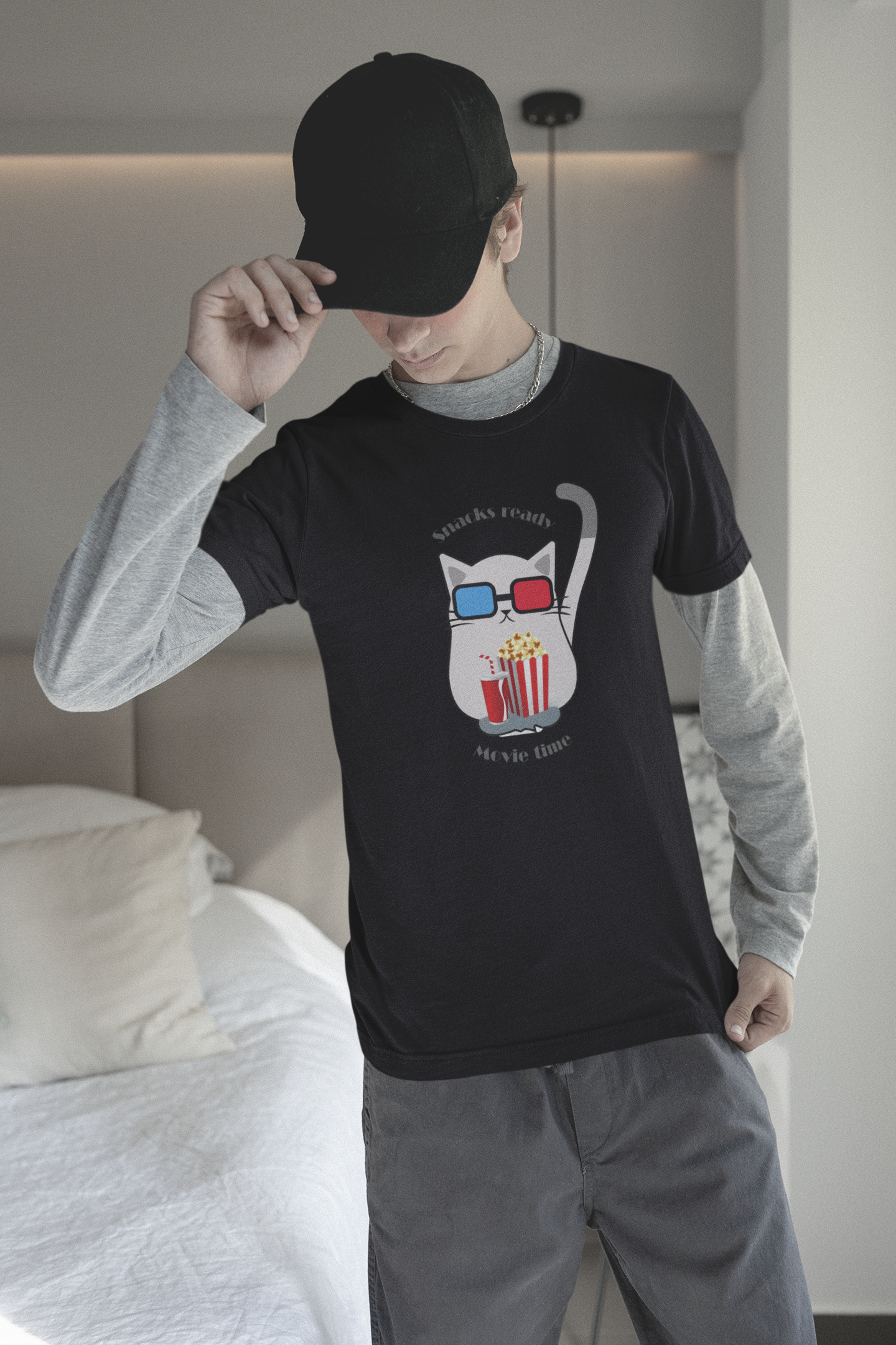 Young man with e-boy style wearing black t-shirt with cat in 3D glasses and snacks ready movie time slogan